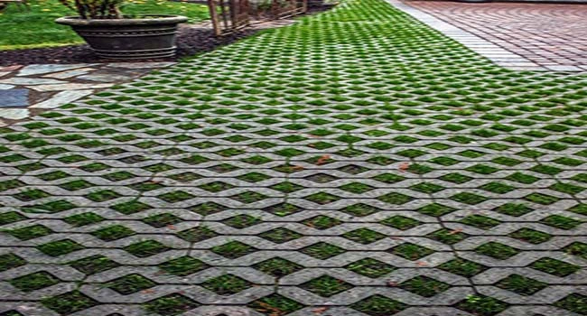 Area carport dan taman dengan pemasangan grass block hijau yang rapi untuk resapan air dan landscape