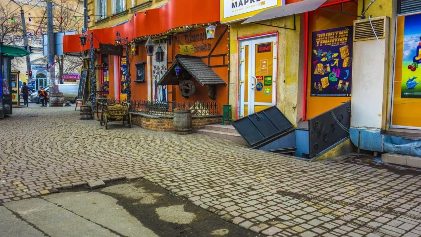 Jalan kota dengan permukaan paving block di depan deretan toko berwarna-warni