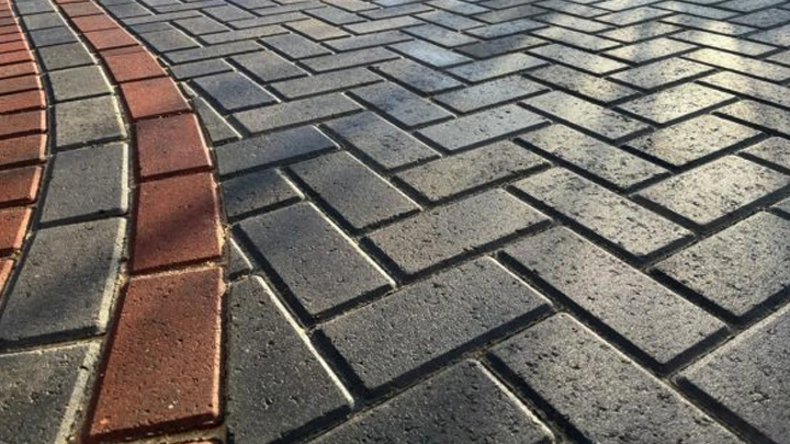 Paving block abu-abu dan merah terpasang rapi dengan pola estetis untuk area jalan dan halaman