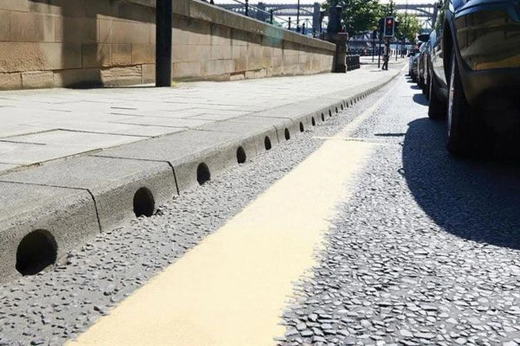 jenis kanstin jalan beton dengan lubang drainase di tepi jalan